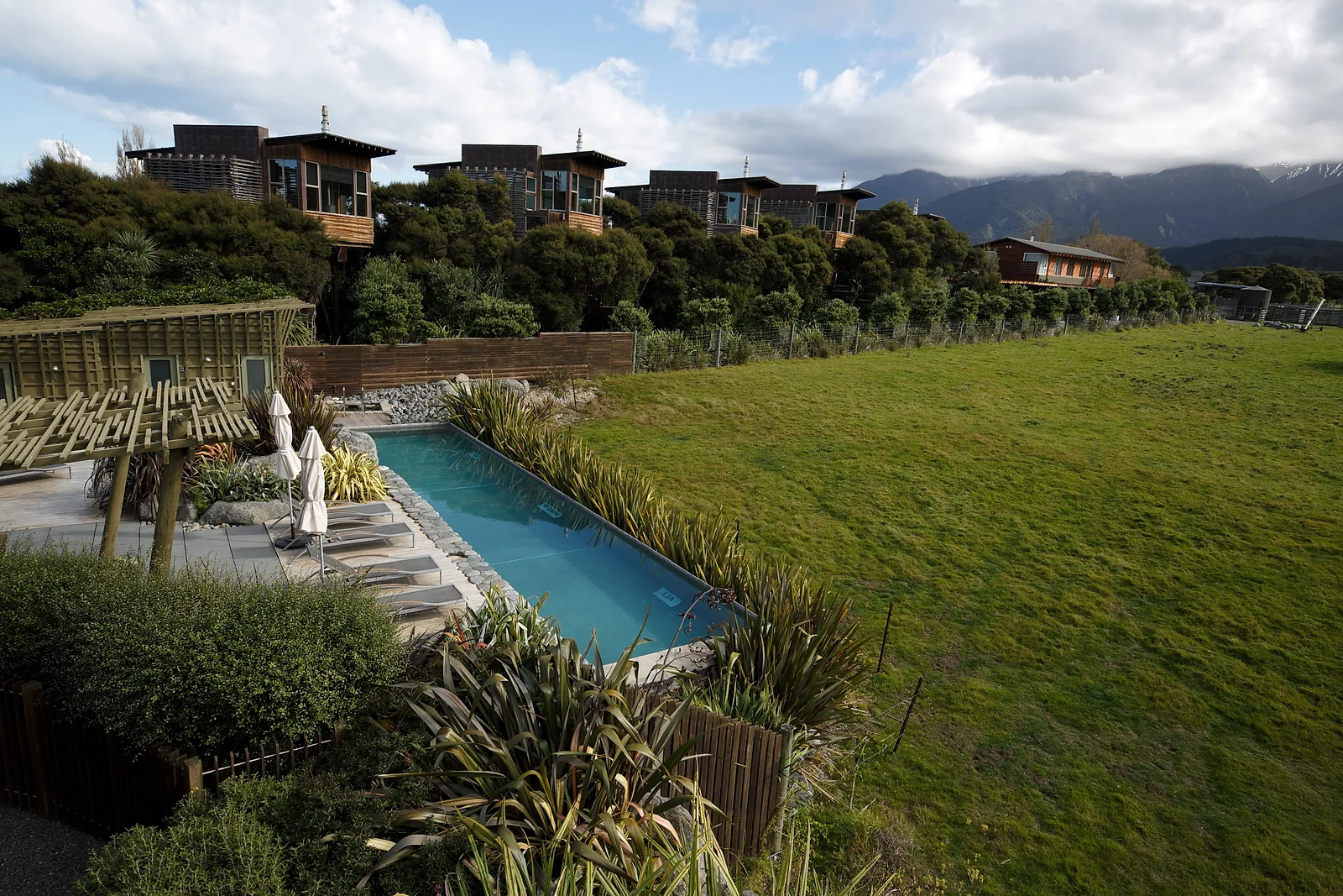 Independent accommodation surrounded by native landscape with a pool and mountain backdrop