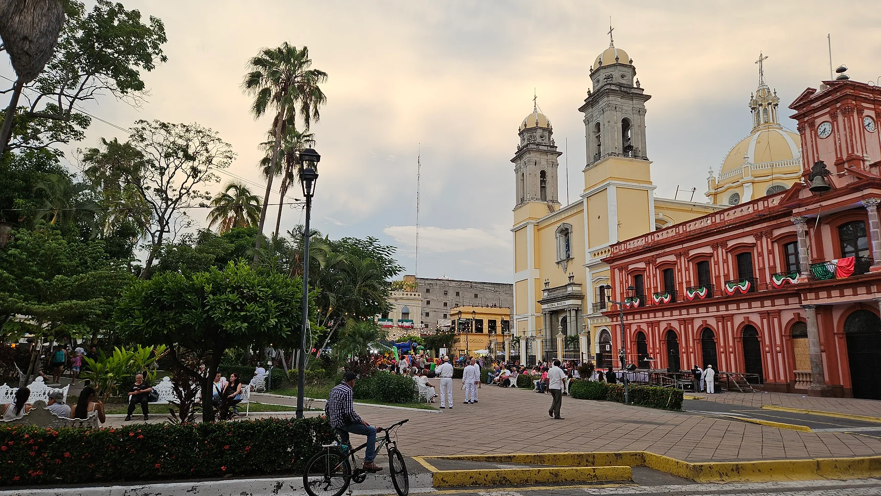 People gathering in a historic Mexican plaza surrounded by local architecture